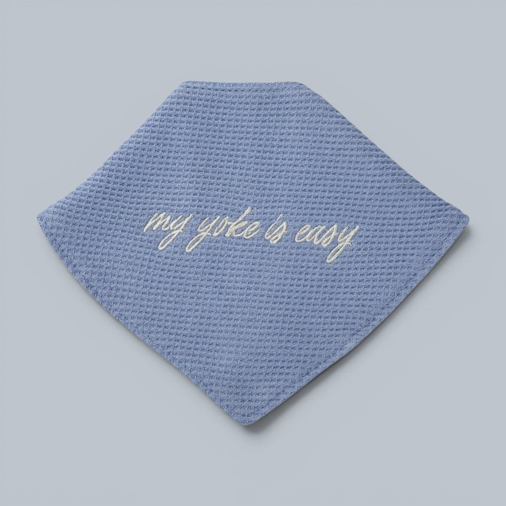 Shalom Living blue waffle bandana bib with embroidered "my yoke is easy" text and snap closure.