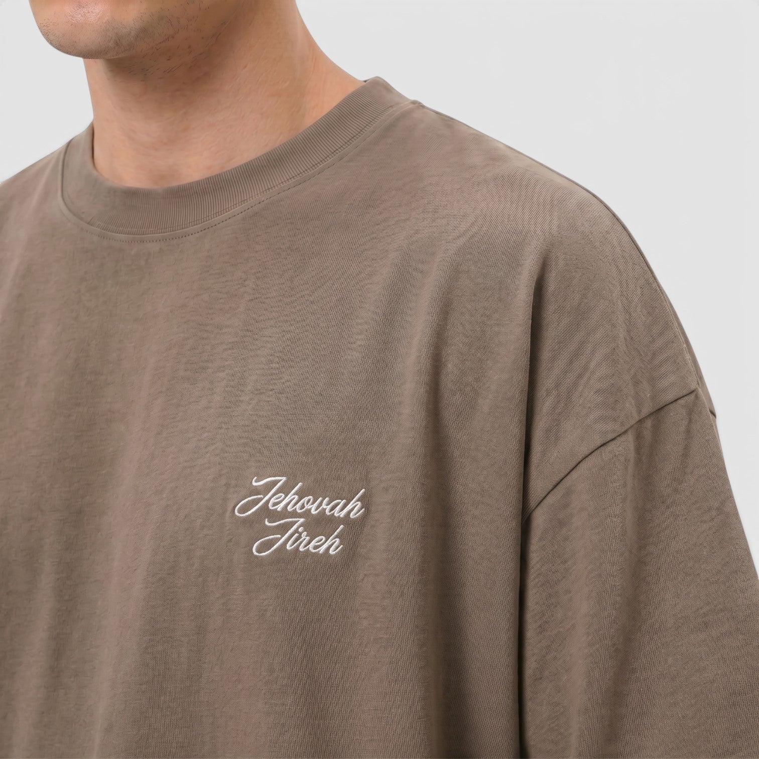 Shalom Living brown cotton boxy t-shirt with white "Jehovah Jireh" embroidery on the chest.