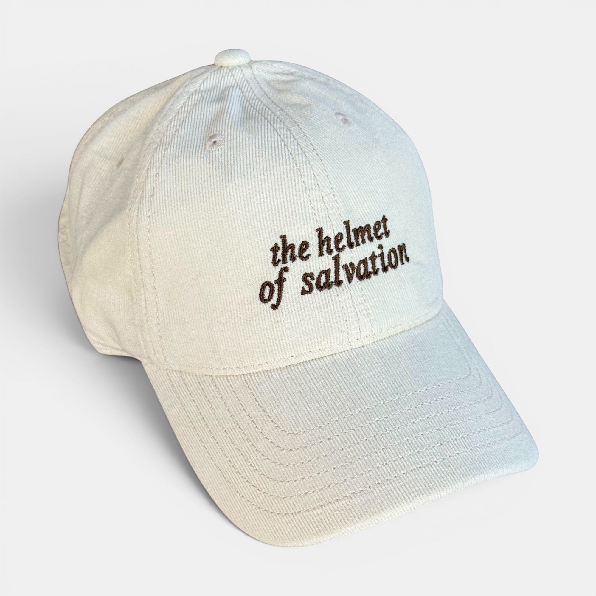 Shalom Living cream corduroy baseball cap with "the helmet of salvation" embroidered in brown.