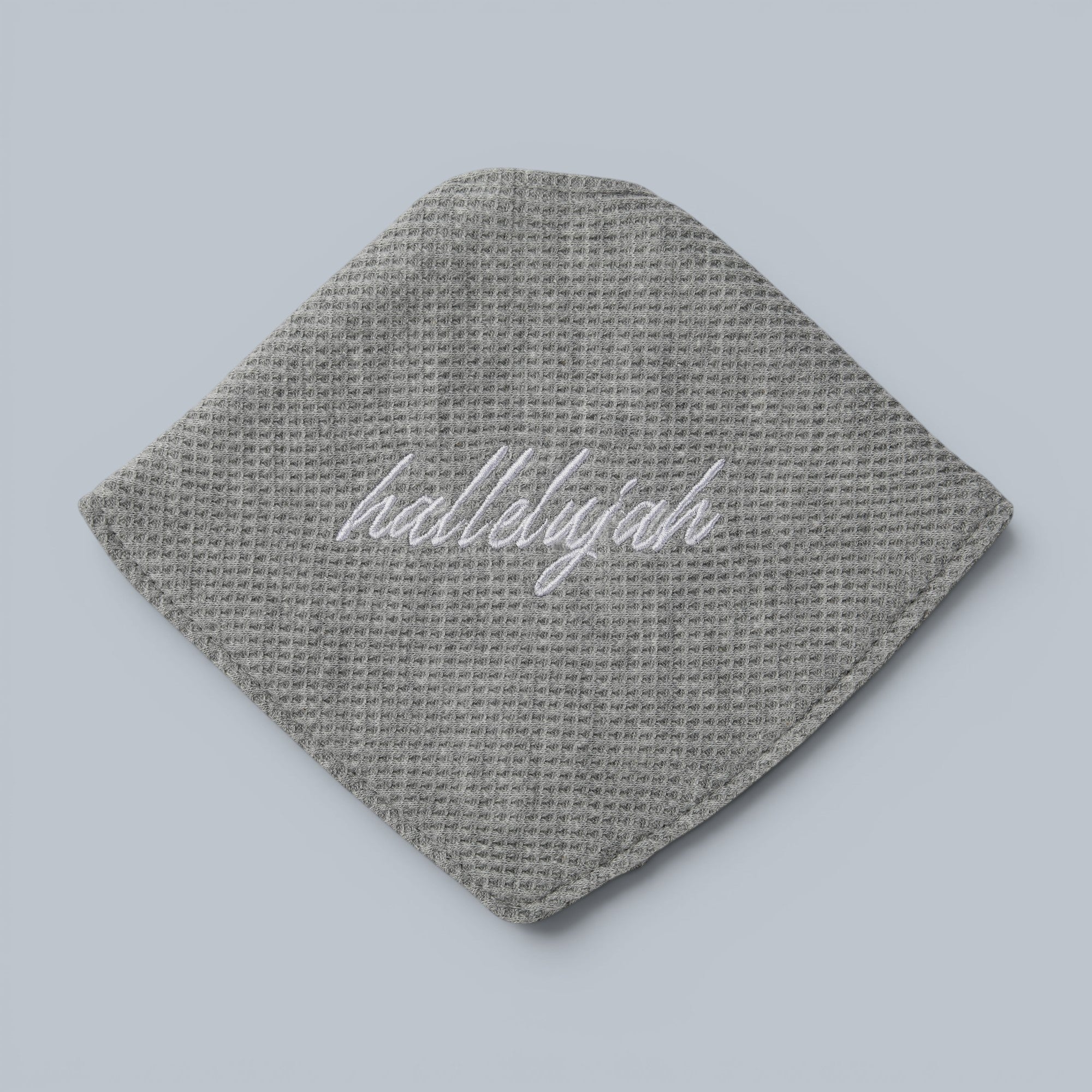 Shalom Living grey waffle bandana bib with white "hallelujah" embroidery and snap closure.