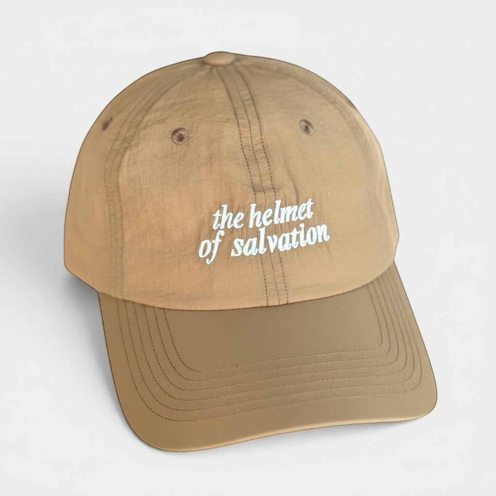 Shalom Living sand-colored outdoor cap with "the helmet of salvation" embroidered in light blue. Lightweight, breathable, adjustable.