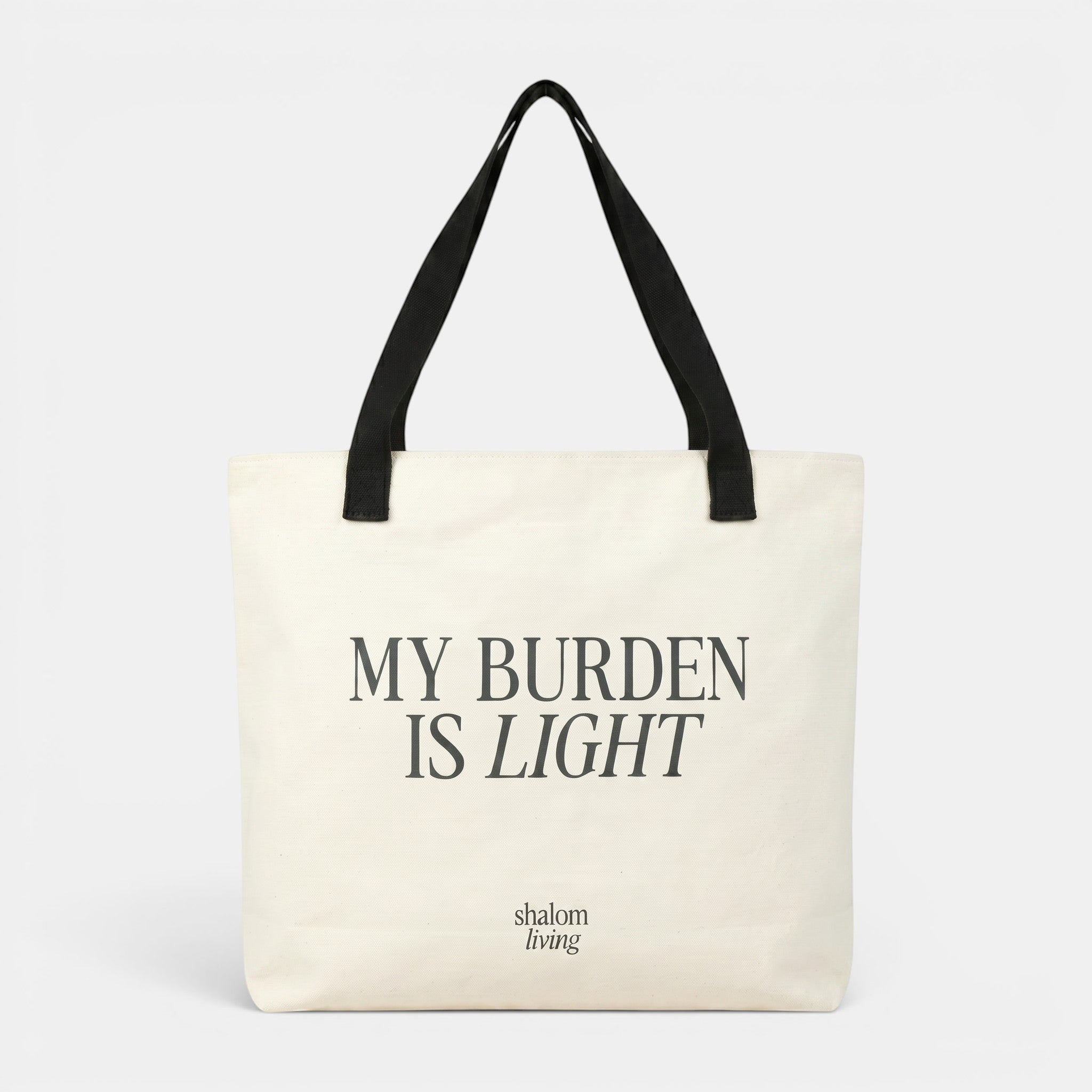Shalom Living My Burden Is Light canvas tote bag with black straps. Features inner pocket and drawstring closure.