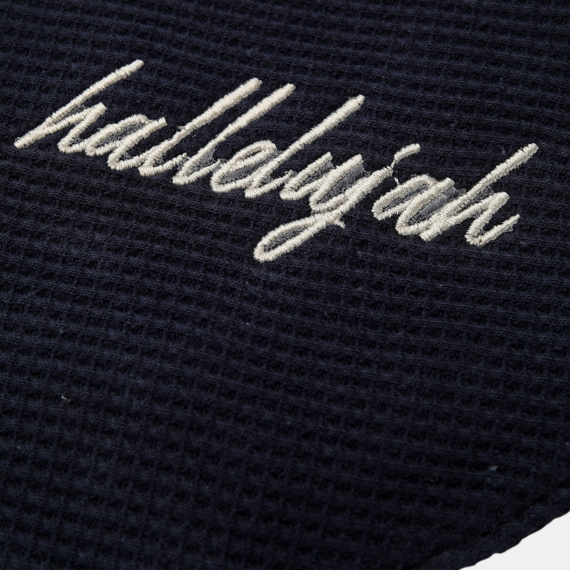 Shalom Living navy blue waffle bandana bib with embroidered "Hallelujah" text. Cotton fabric with snap closure.