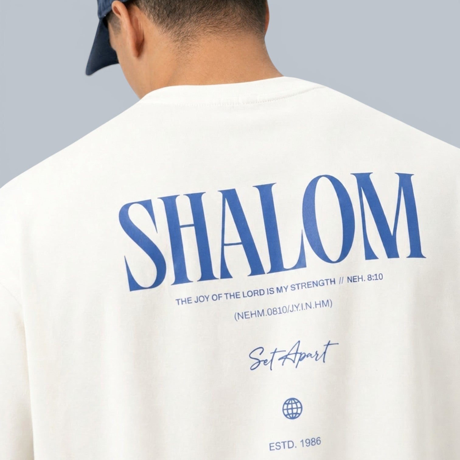 Shalom Living oversized cream cotton t-shirt with blue "SHALOM" graphic and scripture.