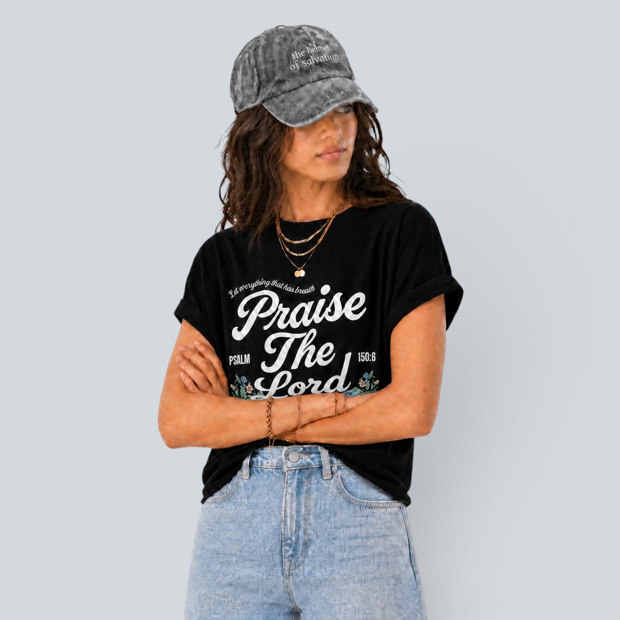 Shalom Living Praise The Lord black cooling t-shirt with white graphic text worn by a woman in light wash jeans.