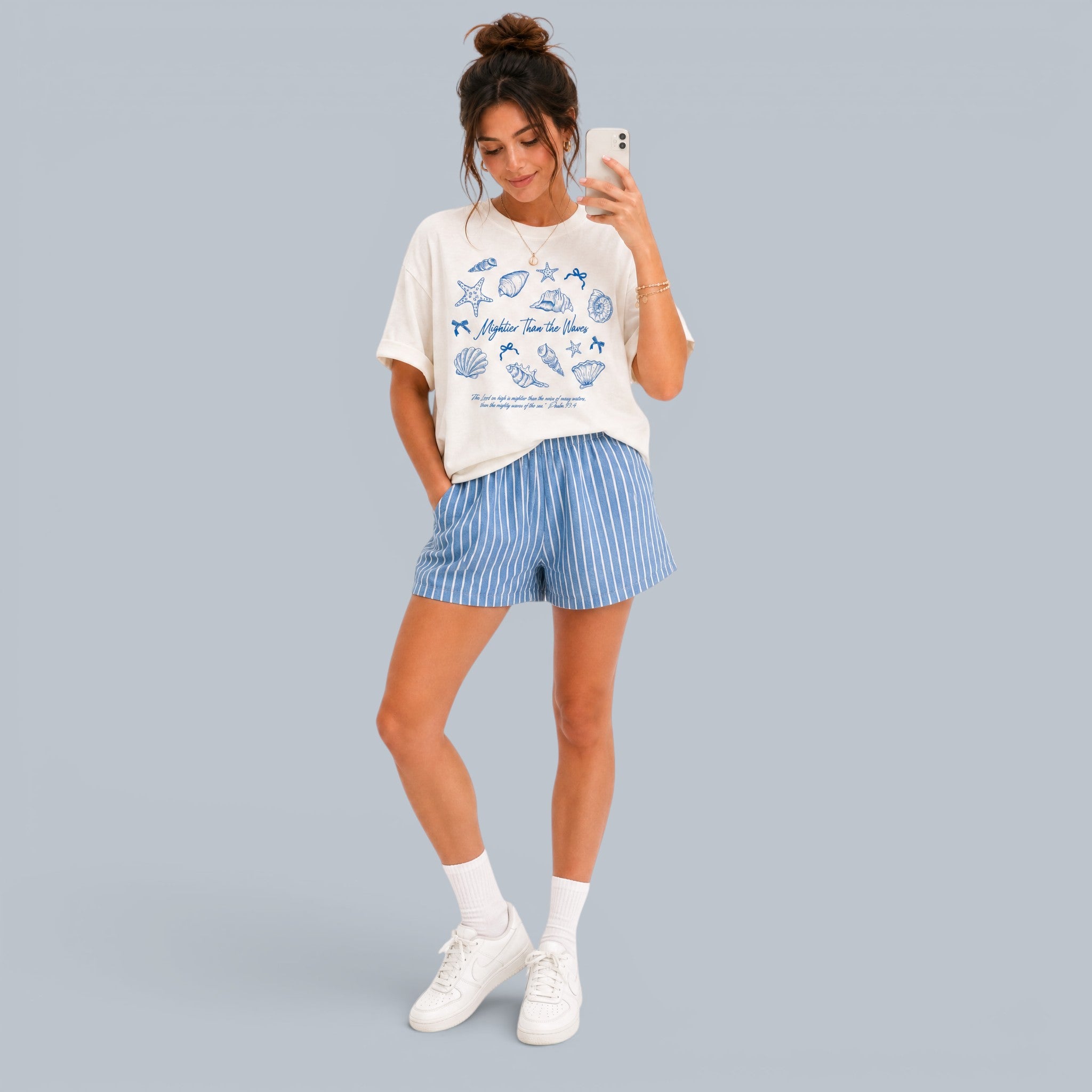 Shalom Living cream relaxed fit t-shirt with blue seashell graphic and text "Mightier Than the Waves".