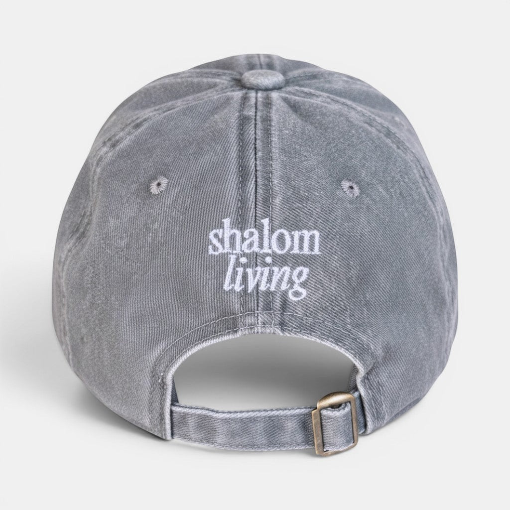Shalom Living vintage washed cotton cap in light grey with embroidered text and adjustable metal buckle.