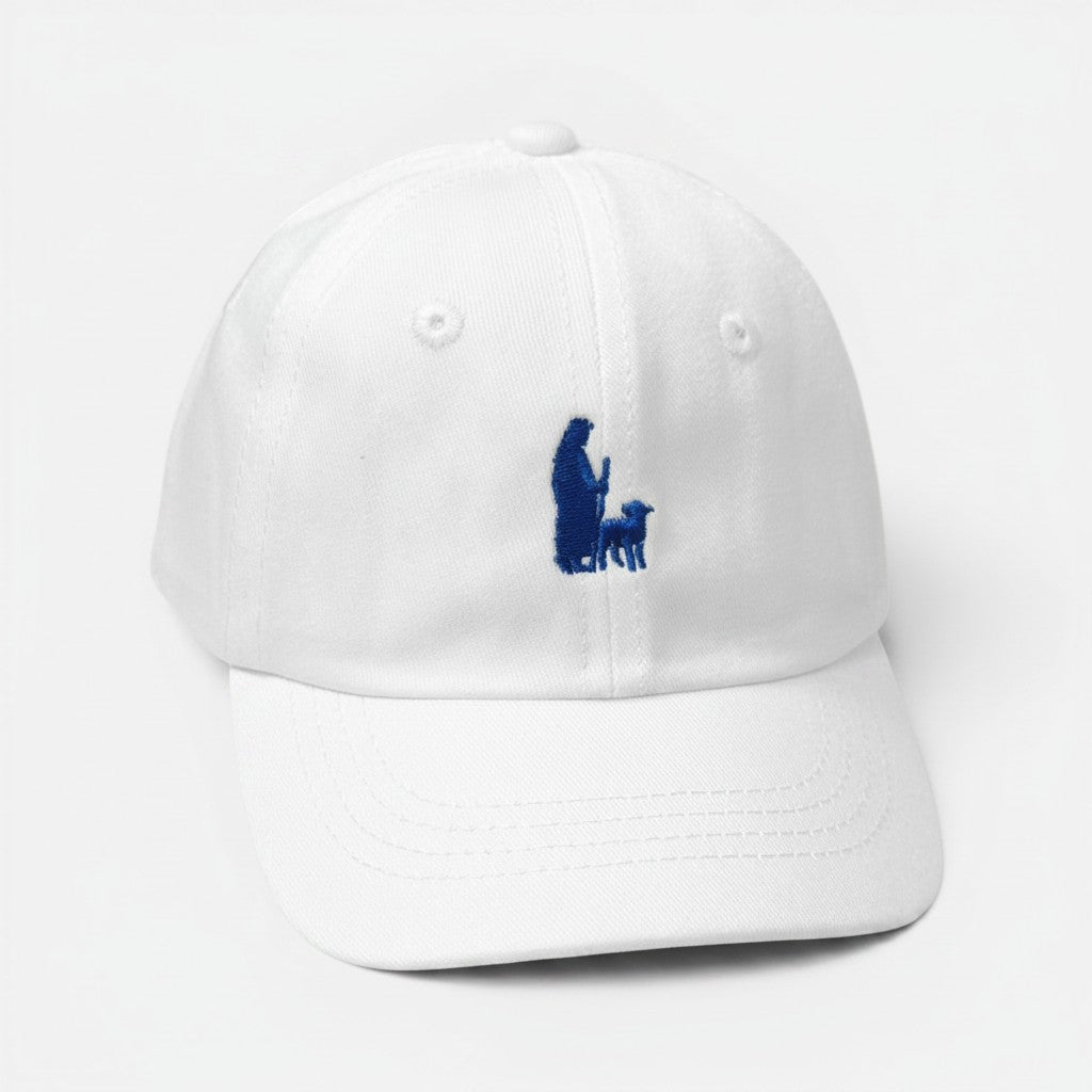 Shalom Living white cotton kids cap with blue embroidered shepherd and lamb design and curved brim.
