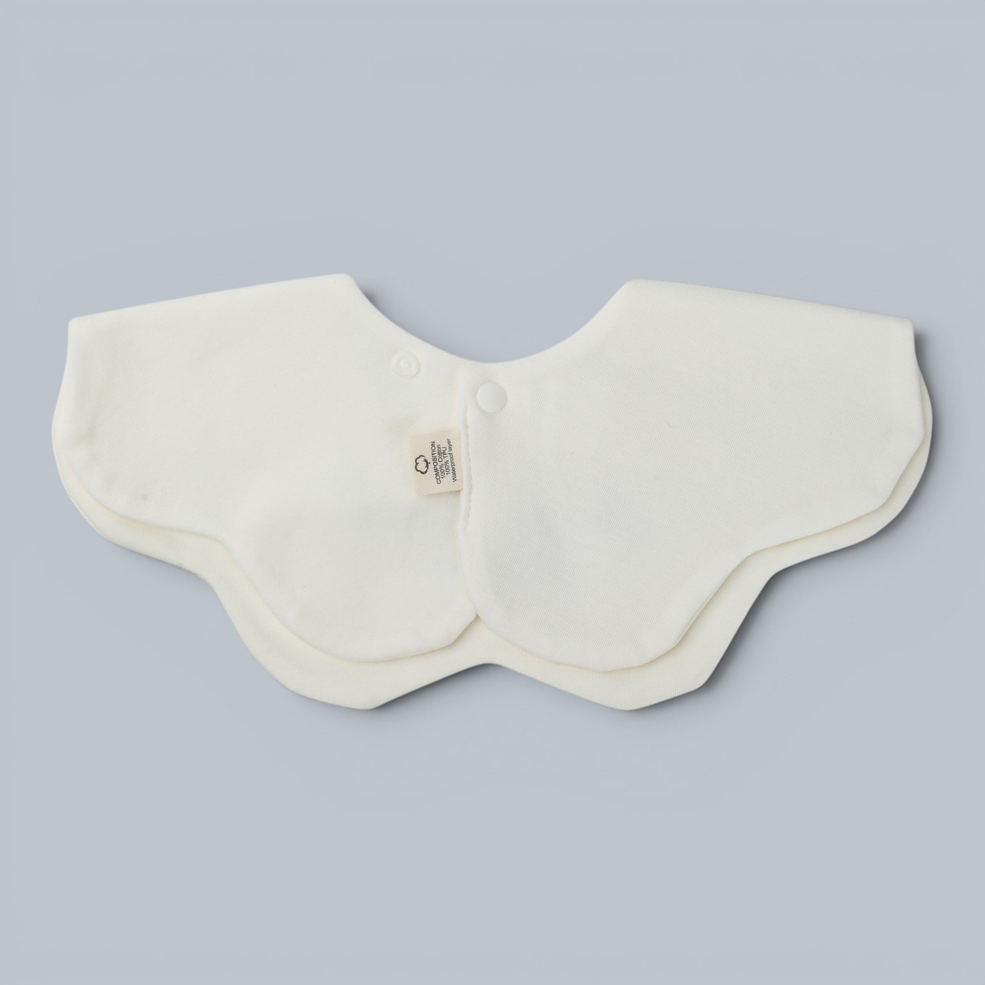 Shalom Living white petal bib with adjustable snap closure and embroidered "Out Of The Mouth Of Babes" phrase. Soft cotton.