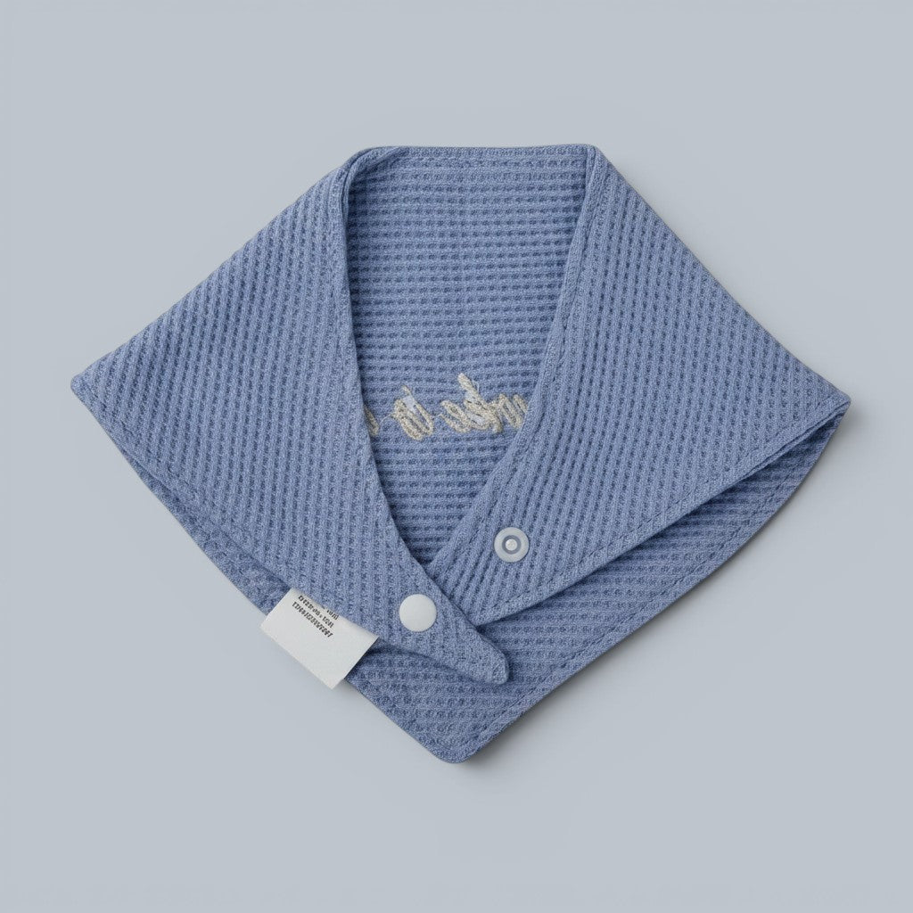 Shalom Living blue waffle bandana bib with embroidered "Hallelujah" text and snap closure. Made of soft cotton.