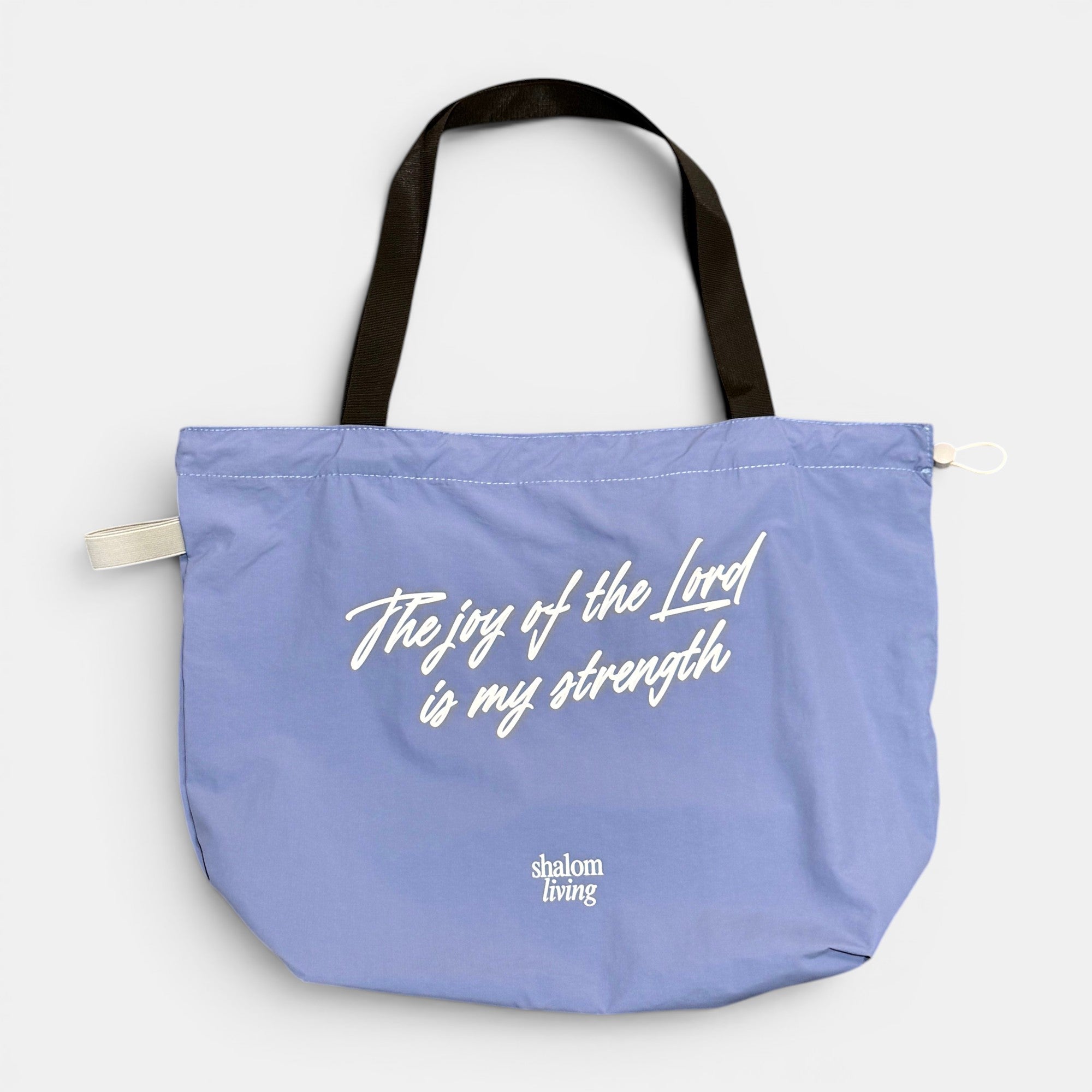 Shalom Living light purple foldable tote bag with white text "The joy of the Lord is my strength"