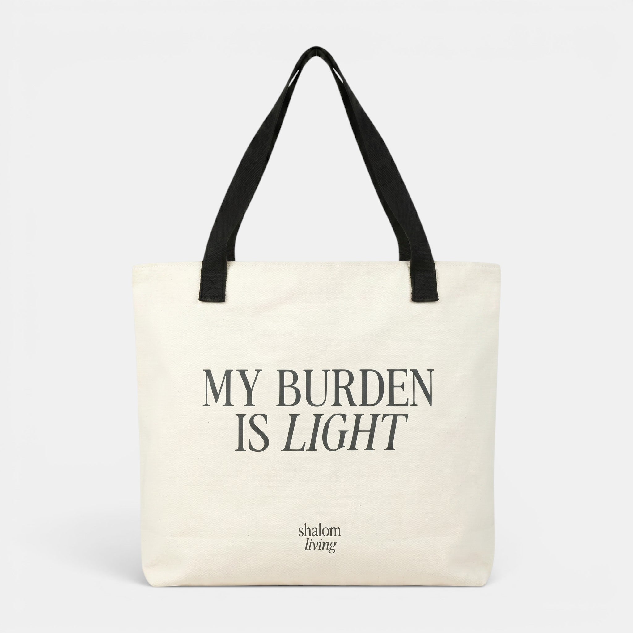 Shalom Living My Burden Is Light canvas tote bag with black straps. Features inner pocket and drawstring closure.