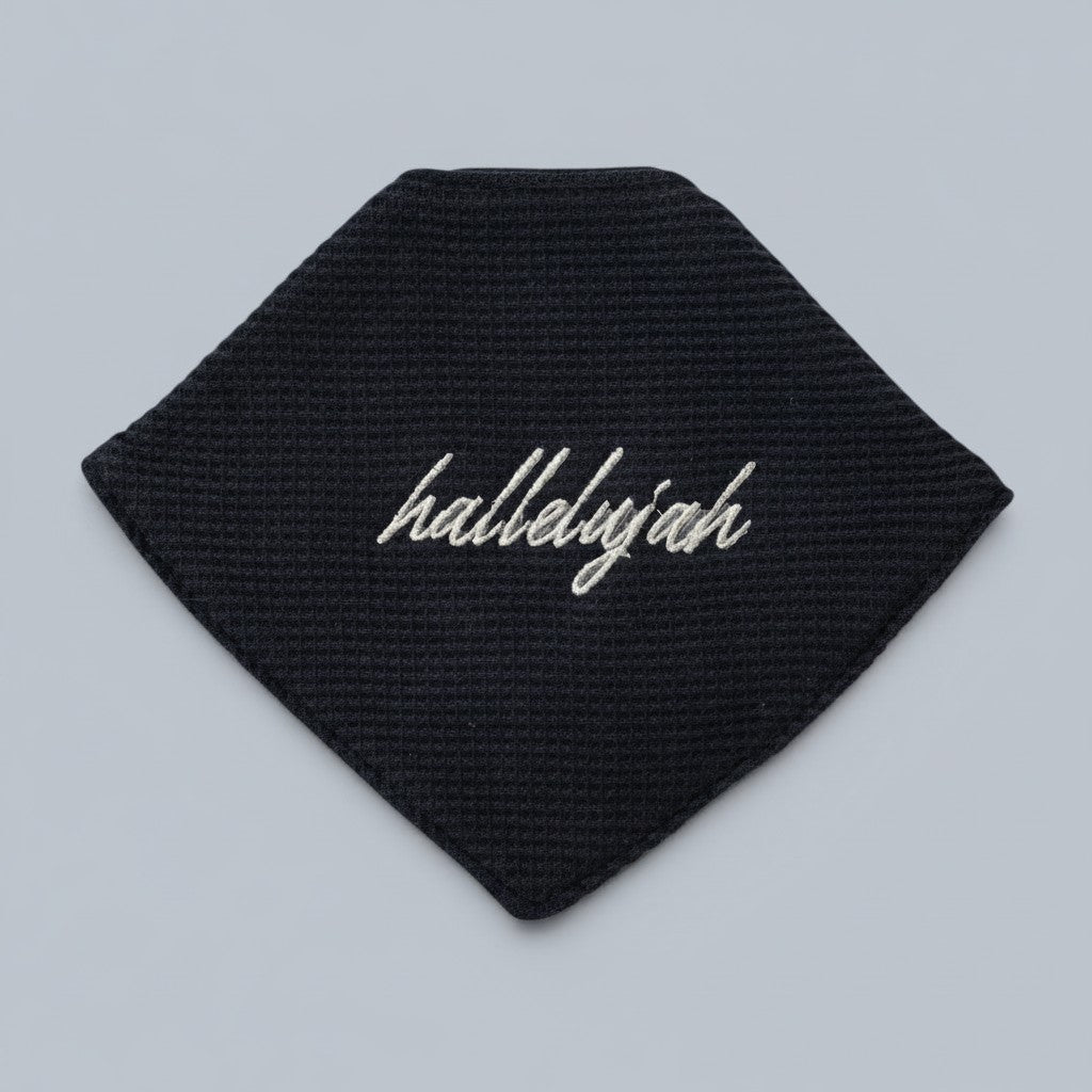Shalom Living dark navy waffle bandana bib with "hallelujah" embroidery. Soft cotton fabric with snap closure.