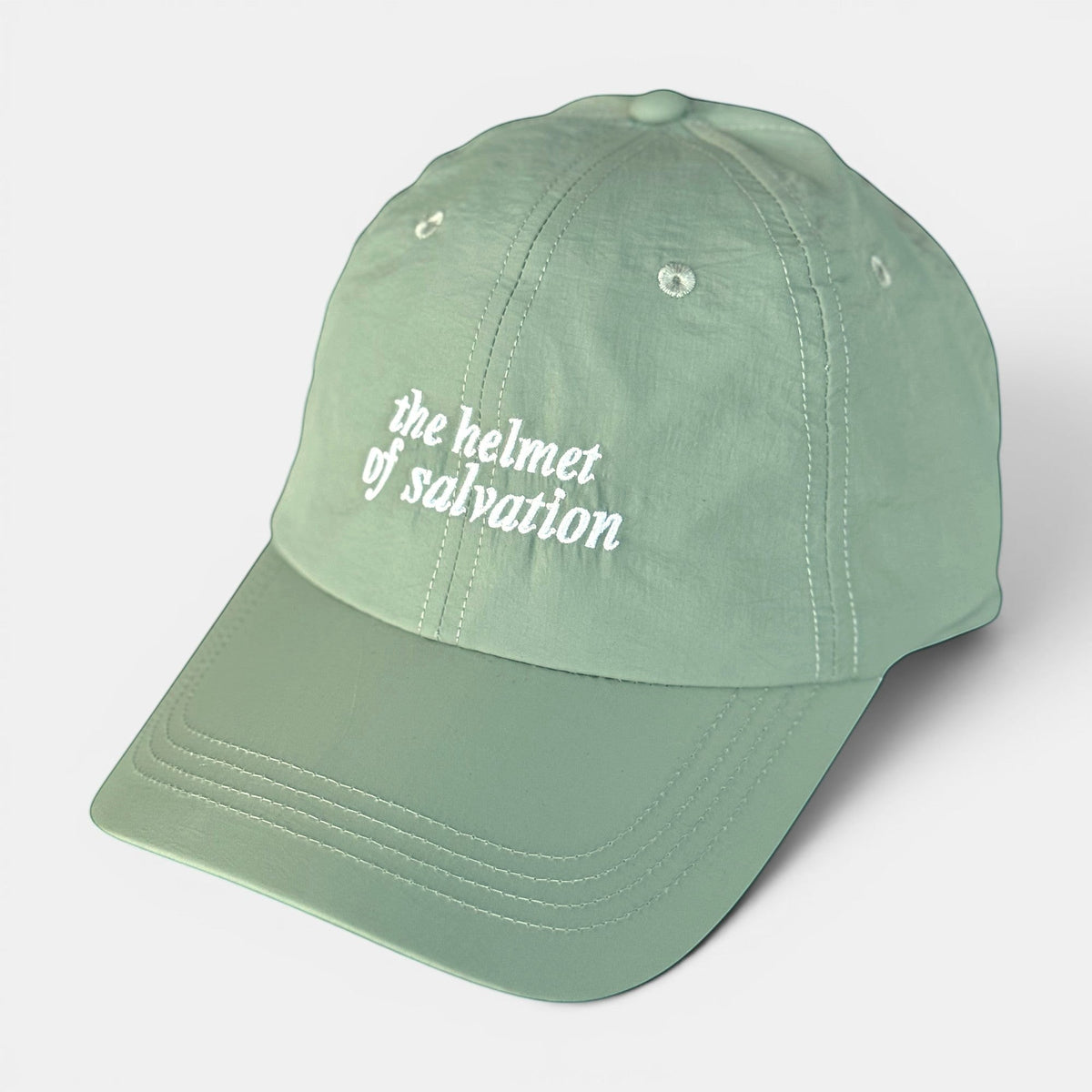 Shalom Living sage green lightweight adjustable outdoor cap with embroidered "the helmet of salvation" text.