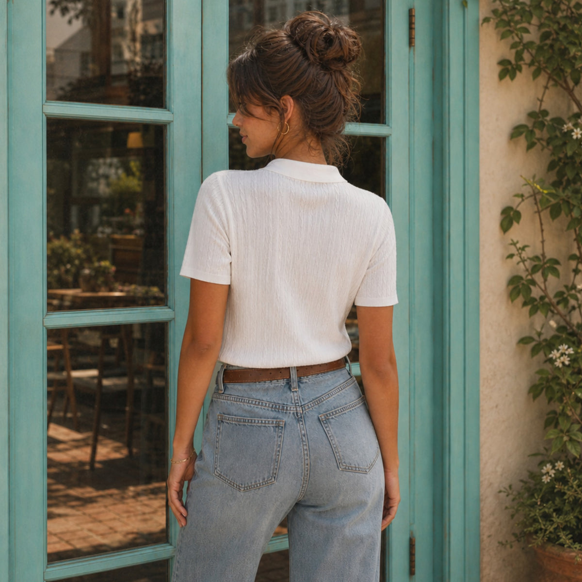 A woman wearing a white Shalom Living cable knit polo shirt with a classic collar, viewed from the back.
