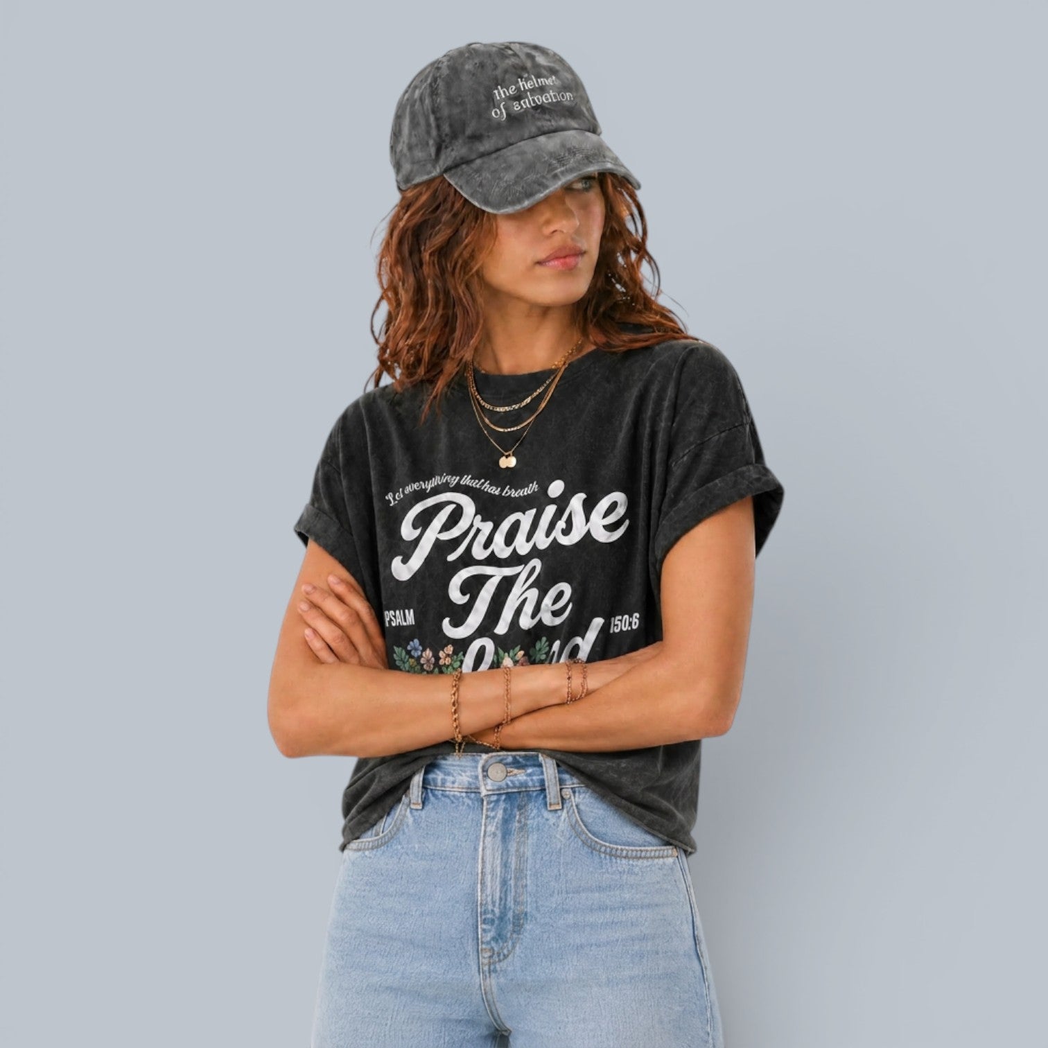 Shalom Living charcoal grey relaxed fit t-shirt with "Praise The Lord" graphic and floral accents. Model wears a grey baseball cap.